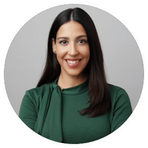 Woman in green top, neutral background.